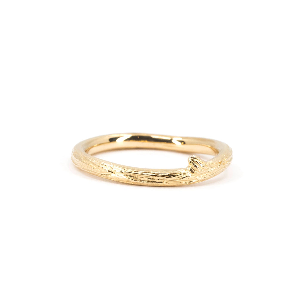 Organic gold ring by Meg Lizabet with a subtle branch-inspired texture and a single sculpted knot detail. The solid yellow gold band shows natural bark-like patterns. Handmade contemporary jewelry from Montreal, available at Ruby Mardi.