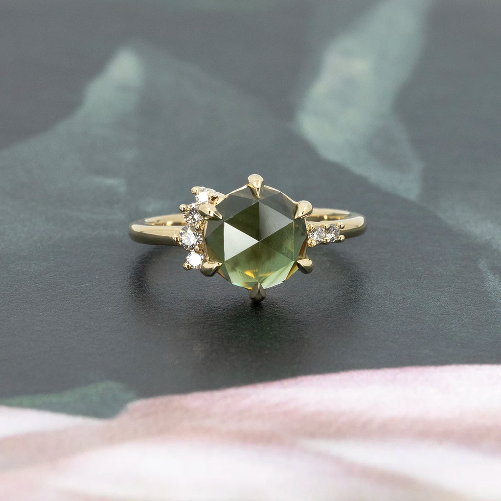 Fluid Jewellery green rose-cut sapphire ring with asymmetrical diamond scatter, set in 14k yellow gold, photographed on floral background, Ruby Mardi Montreal.