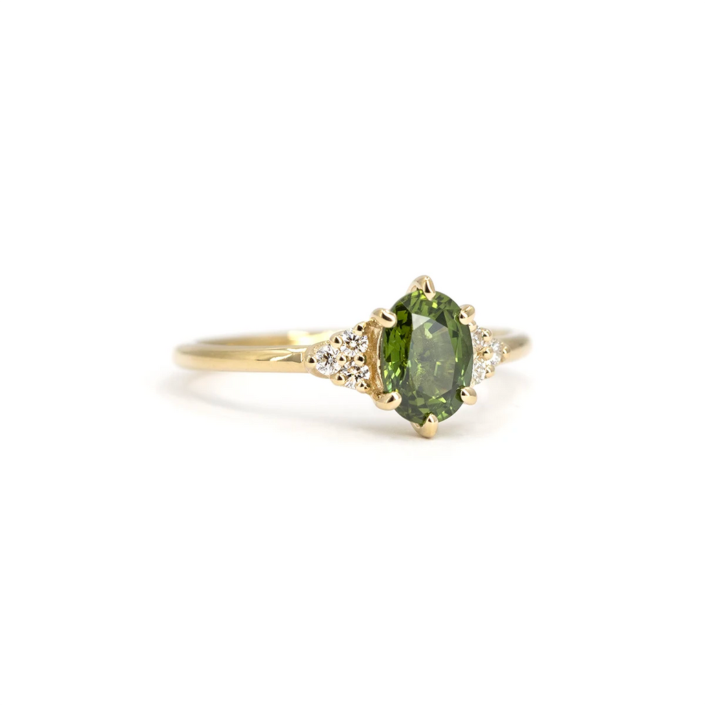 Oval green sapphire ring with cluster diamond setting in yellow gold. Handmade by Maksym Jewelry, available at Ruby Mardi in Montreal.