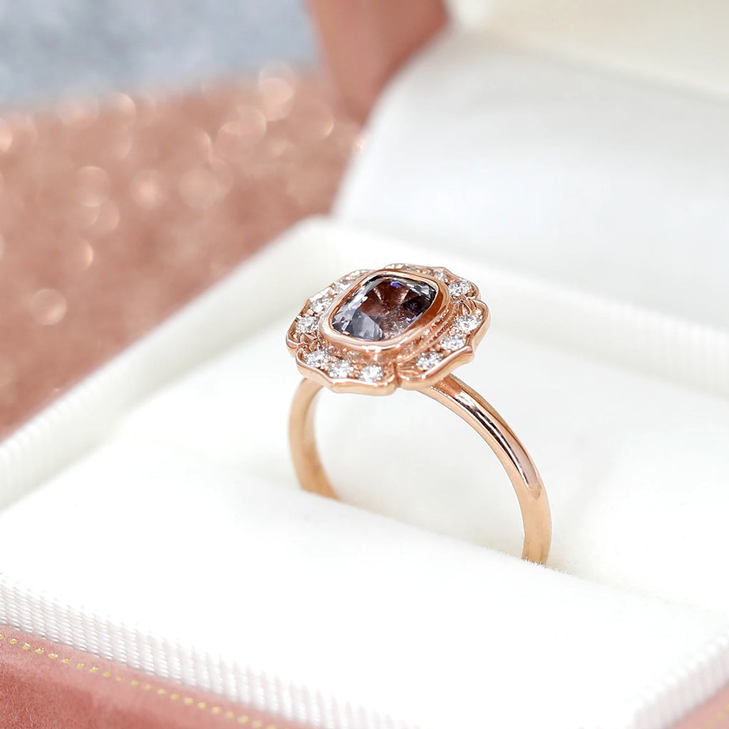 This rose gold engagement ring with gray purple spinel set in rose gold with small diamonds set in it is made by independent jewelry designer Deborah Lavery. This fine piece of jewelry is available for sale at the Ruby Mardi jewelry store, which specializes in wedding jewelry and one-of-a-kind engagement rings.