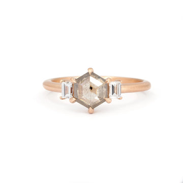 Classic rose gold engagement ring with a hexagonal champagne diamond and two baguette-cut white diamonds, set with eagle claws, photographed on a white background. Made with Fairmined-certified gold by Ottawa-based independent brand Fluid Jewellery. A fine jewelry piece available at Ruby Mardi, a jewelry store specializing in unique designer jewelry, as does Gem Breakfast.