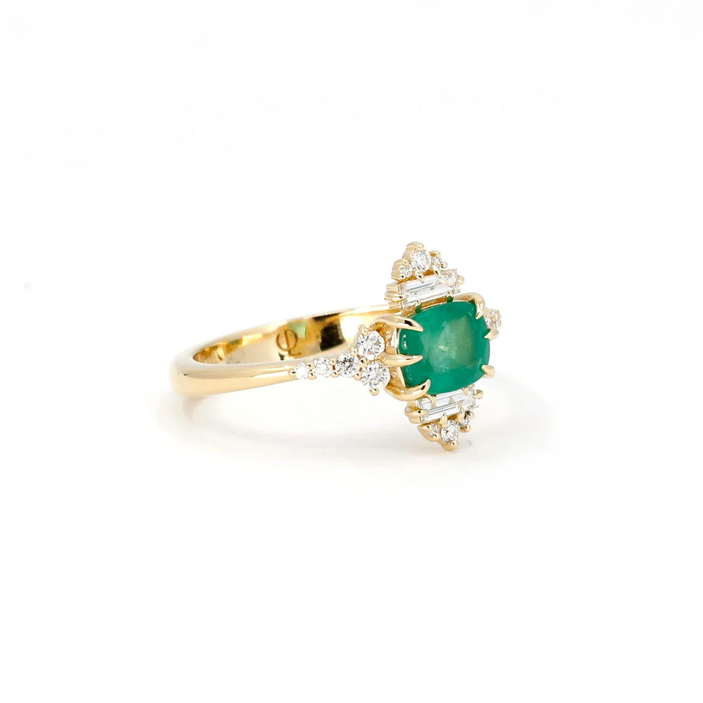 This splendid engagement ring with a cushion-shaped emerald and numerous diamonds set in yellow gold. This financial ring is an alternative to a revisited vintage design. Made in Canada, this unusual bridal ring is made by independent jewelry designer Oleg Leybman in collaboration with Ruby Mardi jewelry store and gallery in Montreal.