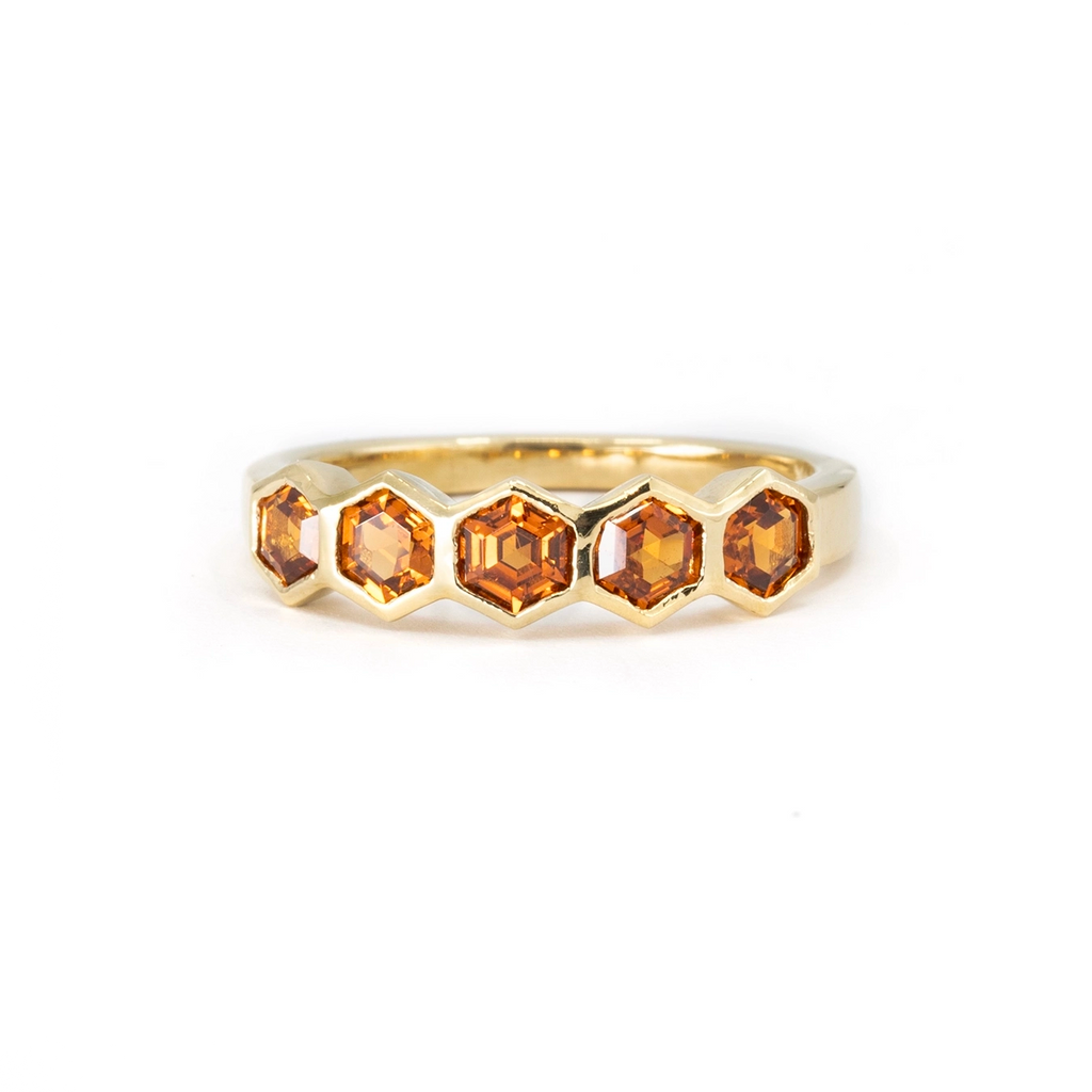 This yellow gold ring with hexagonal spesspartite garnet made by the independent jewelry designer In the Light of Day. With a closed setting, these natural gems give an edgy and unique style for this fine jewel. Available for sale at the Ruby Mardi jewelry store located in Montreal in Little Italy.