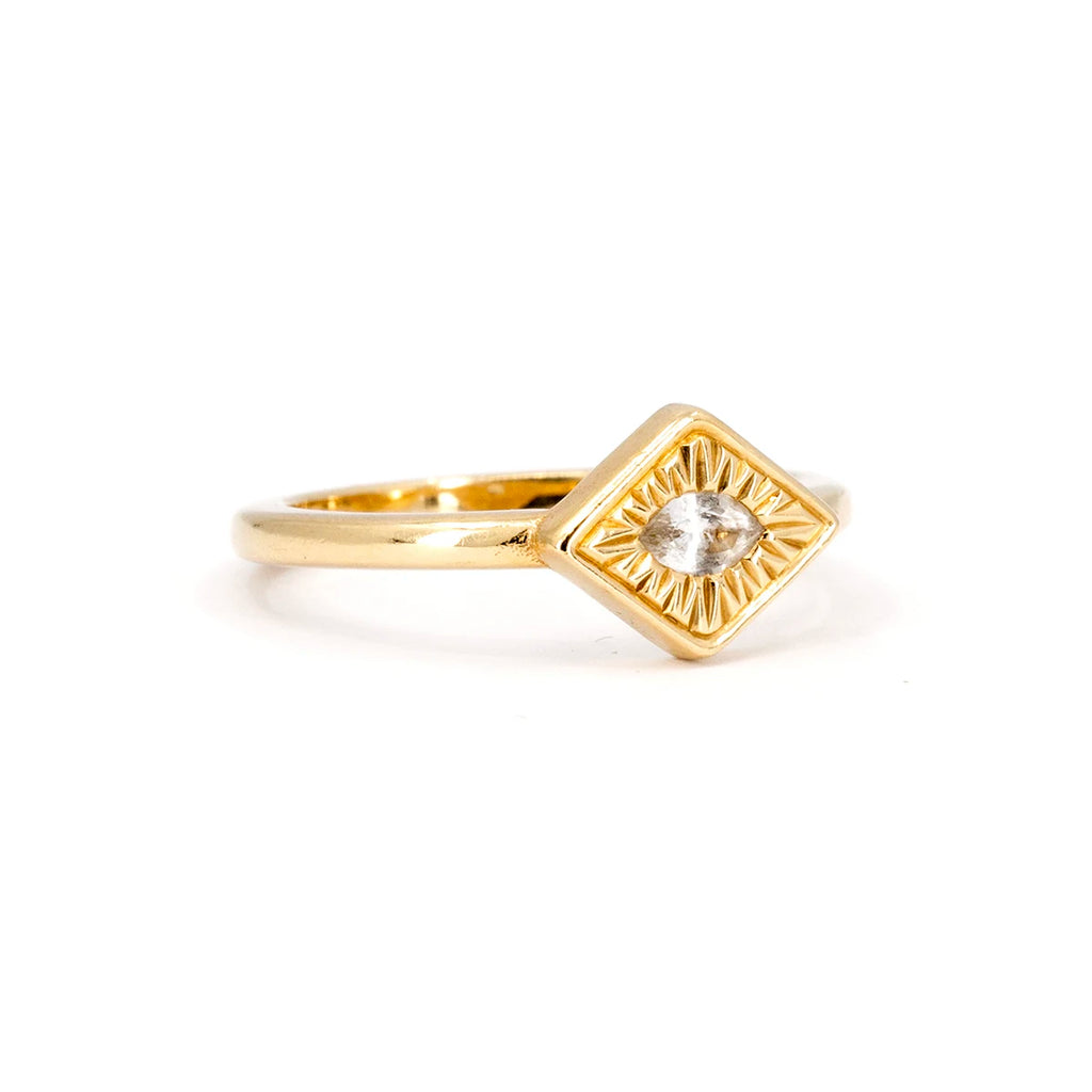 Half side view of a yellow gold ring with hand engraved details and a central marquise white sapphire. This designer engagement ring is available at Canadian jewelry store Ruby Mardi.