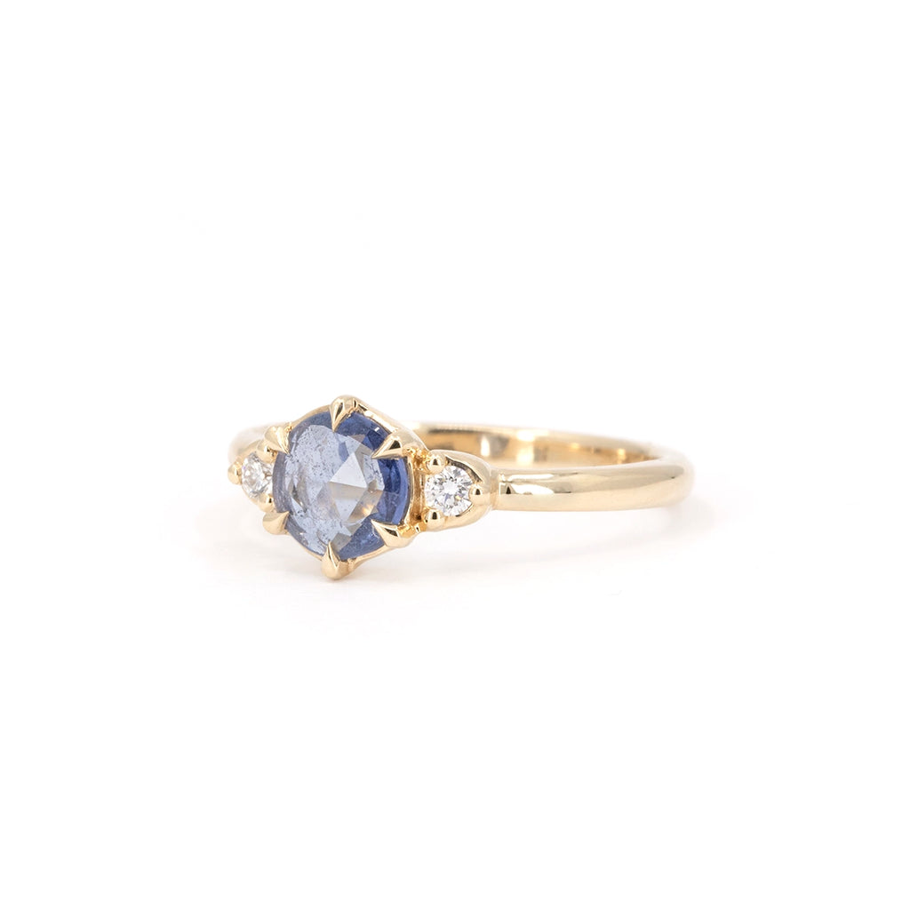 Light blue rose-cut sapphire engagement ring in 14k yellow gold with side diamonds, handcrafted by Yuliya Chorna, photographed at Ruby Mardi Montreal, Canada.
