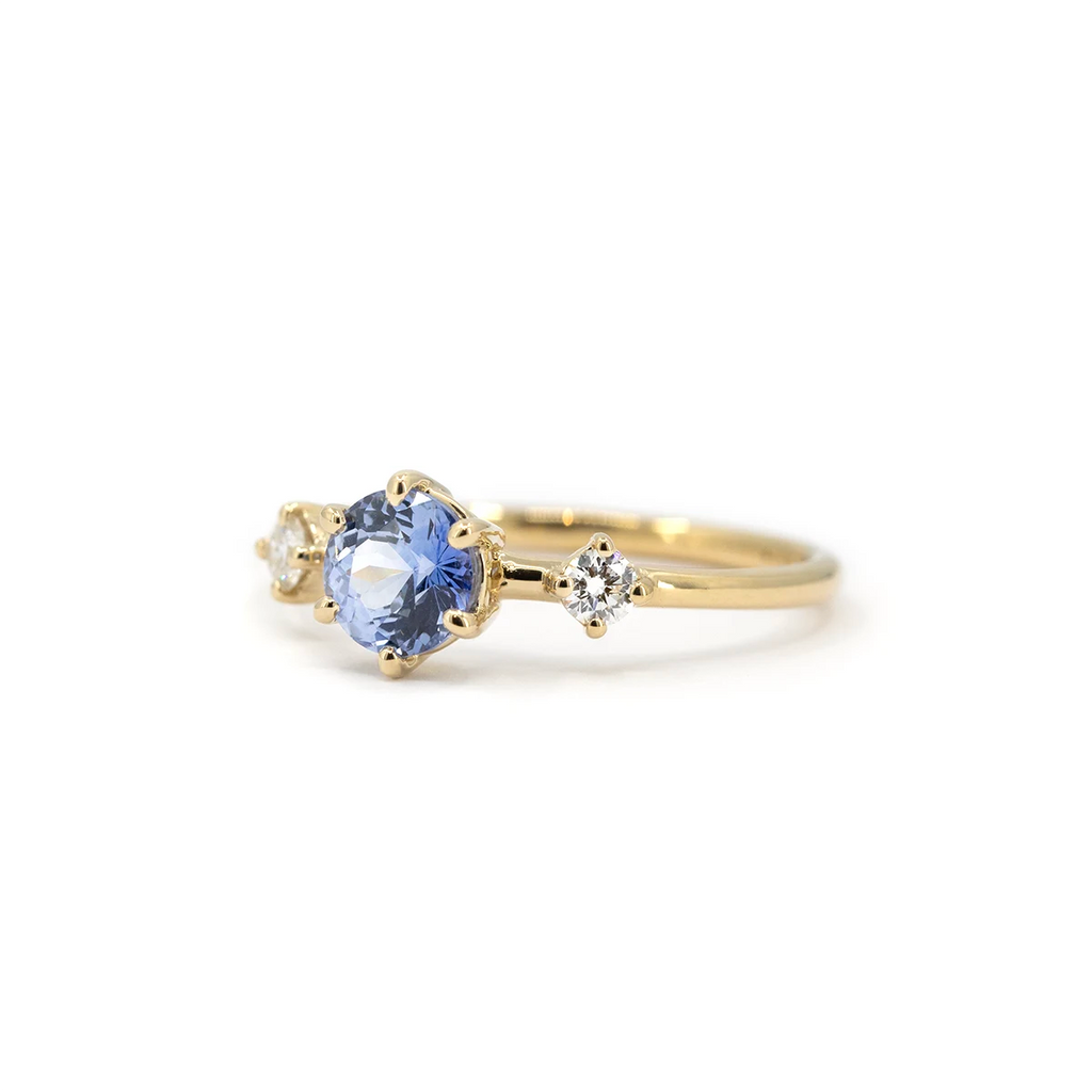 Side view of light blue sapphire and diamond engagement ring in yellow gold. Handmade by Maksym Jewelry in Montreal, available at Ruby Mardi.