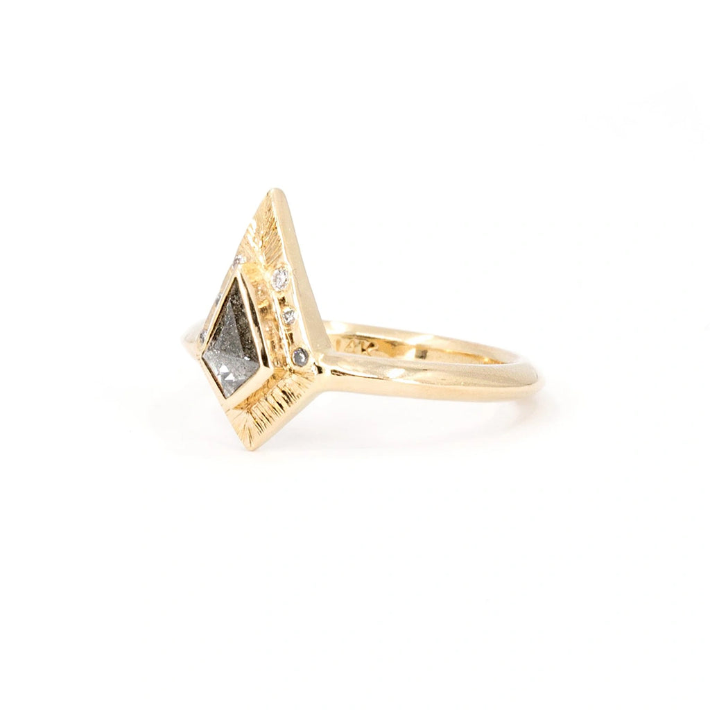 Unique engagement ring in yellow gold, with a central salt-and-pepper kite-shaped diamond and diamond accents. Handcrafted by independent Canadian brand Rebel & Rogue. Available at Ruby Mardi, the coolest jewelry store in Canada. The jewel is seen on a white background, from its side.