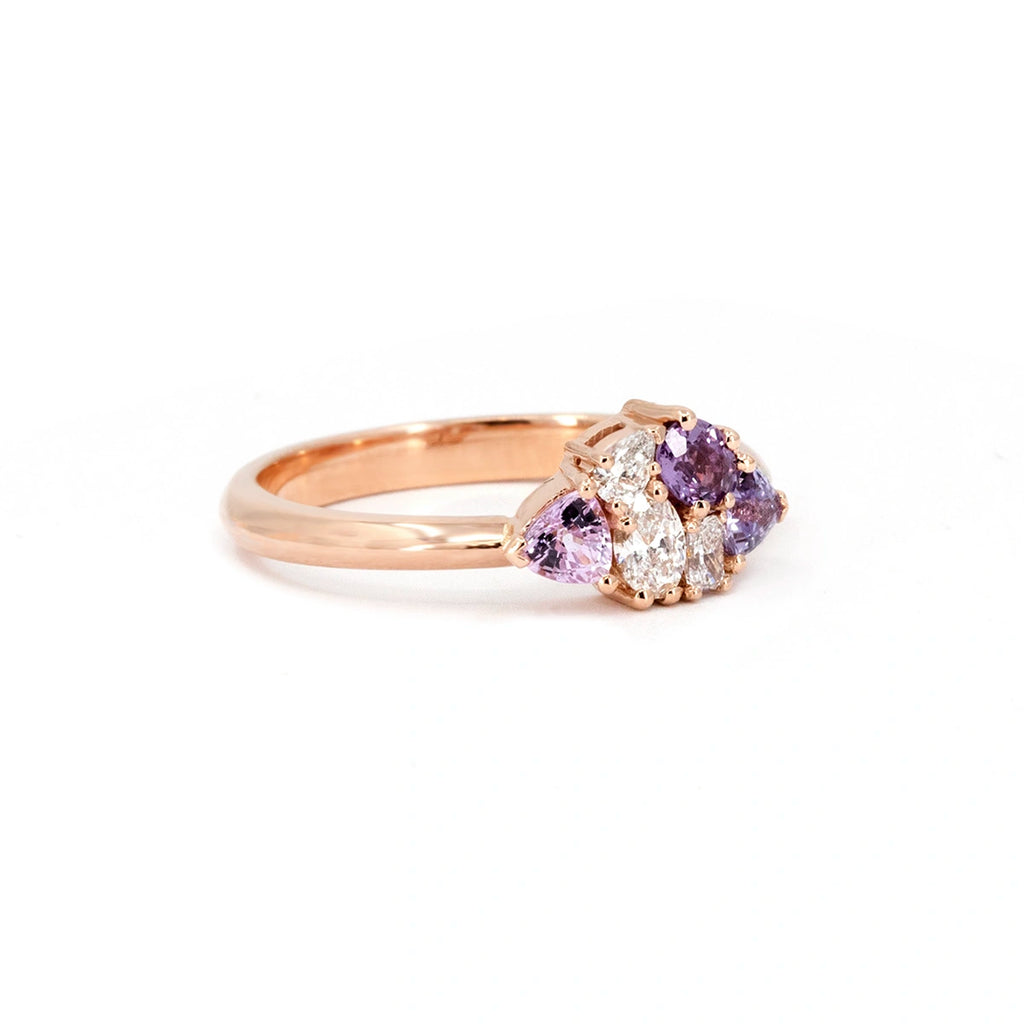 A side view of a 14k rose gold cluster ring featuring three light purple sapphires and three lab-grown diamonds. This dainty, vintage-inspired design by Ruby Mardi highlights its intricate setting and elegant craftsmanship.
