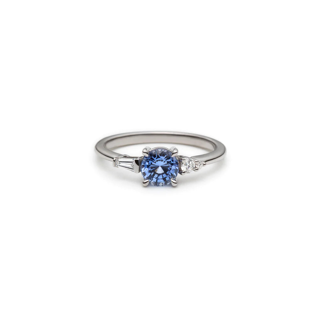 Engagement ring handmade in Canada by jewelry designer Justine Quintal. Delicate ring made in white gold with a round blue sapphire and two beautiful natural diamonds placed asymmetrically. This custom creation is exclusive to Ruby Mardi jewelry store in Montreal's Little Italy.
