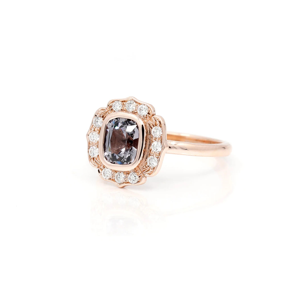 Ruby Mardi jewelry presents the fincialles ring in rose gold with gray spinel and diamond made by independent jewelry designer Deborah Lavery. Made with a splendid cushion-shaped gray spinel with a bezel-set diamond halo to give this bridal ring a vintage and elegant style.