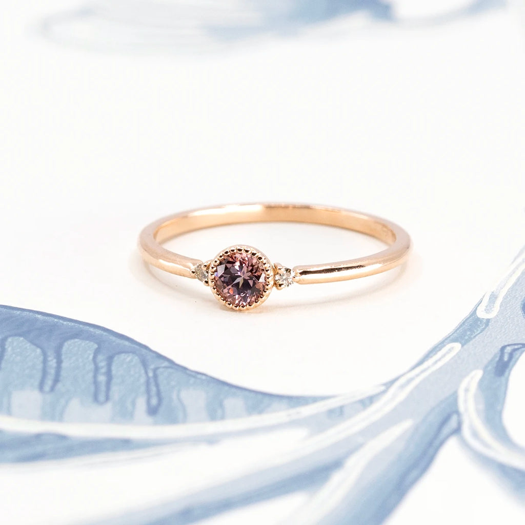Malaya garnet bridal ring in 18 karat rose gold photographed on an artistic background. Handmade jewelry by independent designers in Canada. 