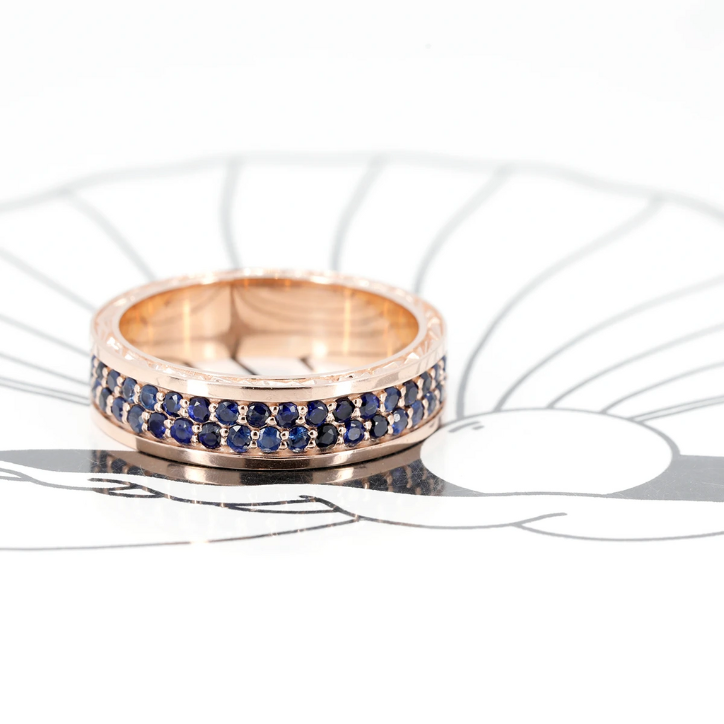 Stunning full eternity men's ring with natural royal blue gem sapphires with rose gold. This independent jewelry designer bridal ring is made by Bena Jewelry is made in Canada and displayed at Ruby Mardi Jewelry Store and Gallery in Montreal.