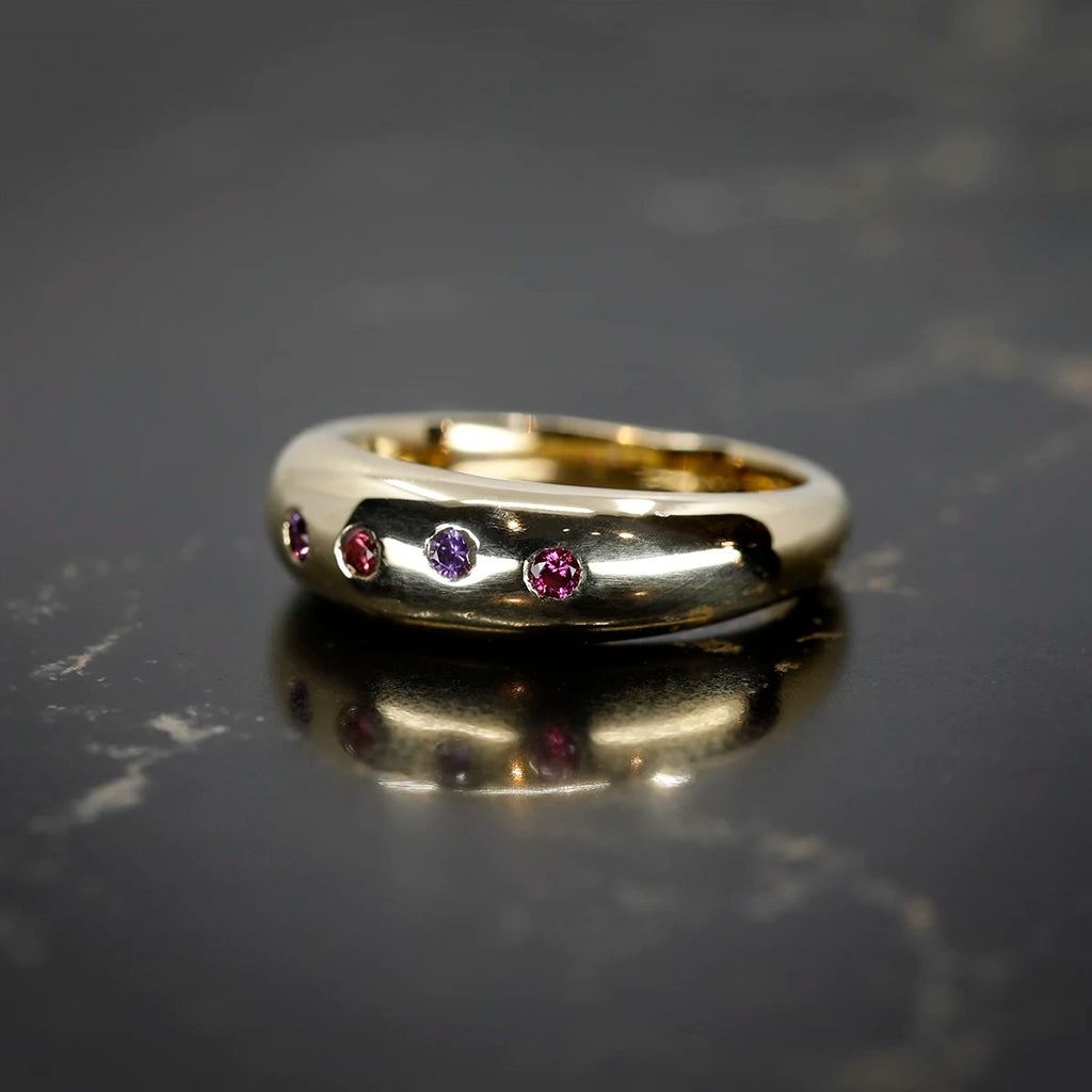 Polished yellow gold dome ring set with scattered pink and purple sapphires. Designed by Marni Bree Jewellery, available at Ruby Mardi, Montreal.