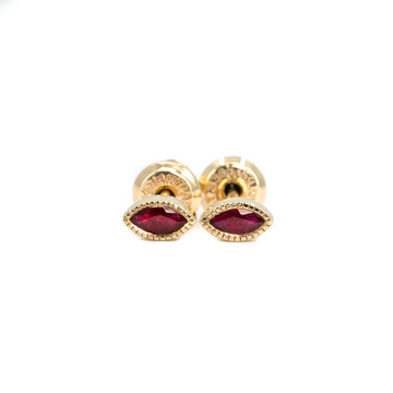 Close-up of marquise ruby stud earrings with milgrain bezel, handcrafted by Emily Gill. Set in 14k yellow gold, shown with screw-back posts. Montreal jewelry at Ruby Mardi.