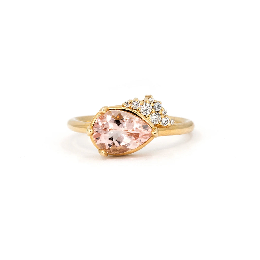 Pear-shaped morganite engagement ring set in yellow gold, featuring a diamond cluster accent. Designed and handcrafted by Ruby Mardi in Montreal, the best jewelry store in Canada. 