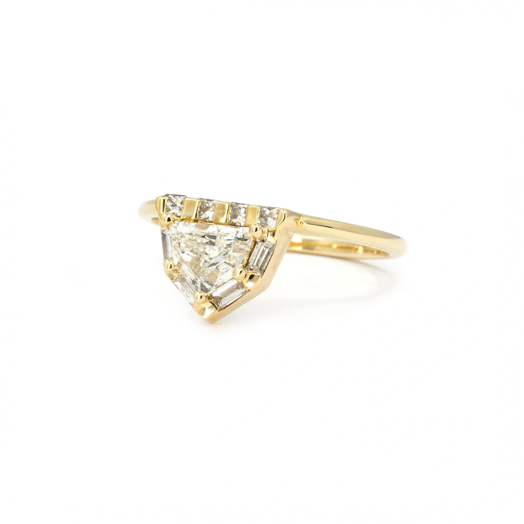 Yellow gold engagement ring featuring a shield-cut natural diamond framed by baguette and princess-cut diamonds. Designed by Anastassia Sel, available at Ruby Mardi, Montreal.