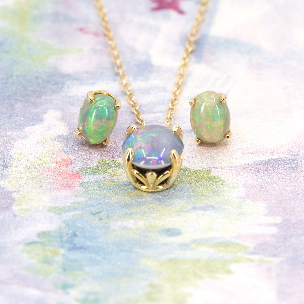 Opal jewelry set with matching necklace and stud earrings in 14k yellow gold on a pastel background. Designed by Rooz Jewellery for Ruby Mardi.