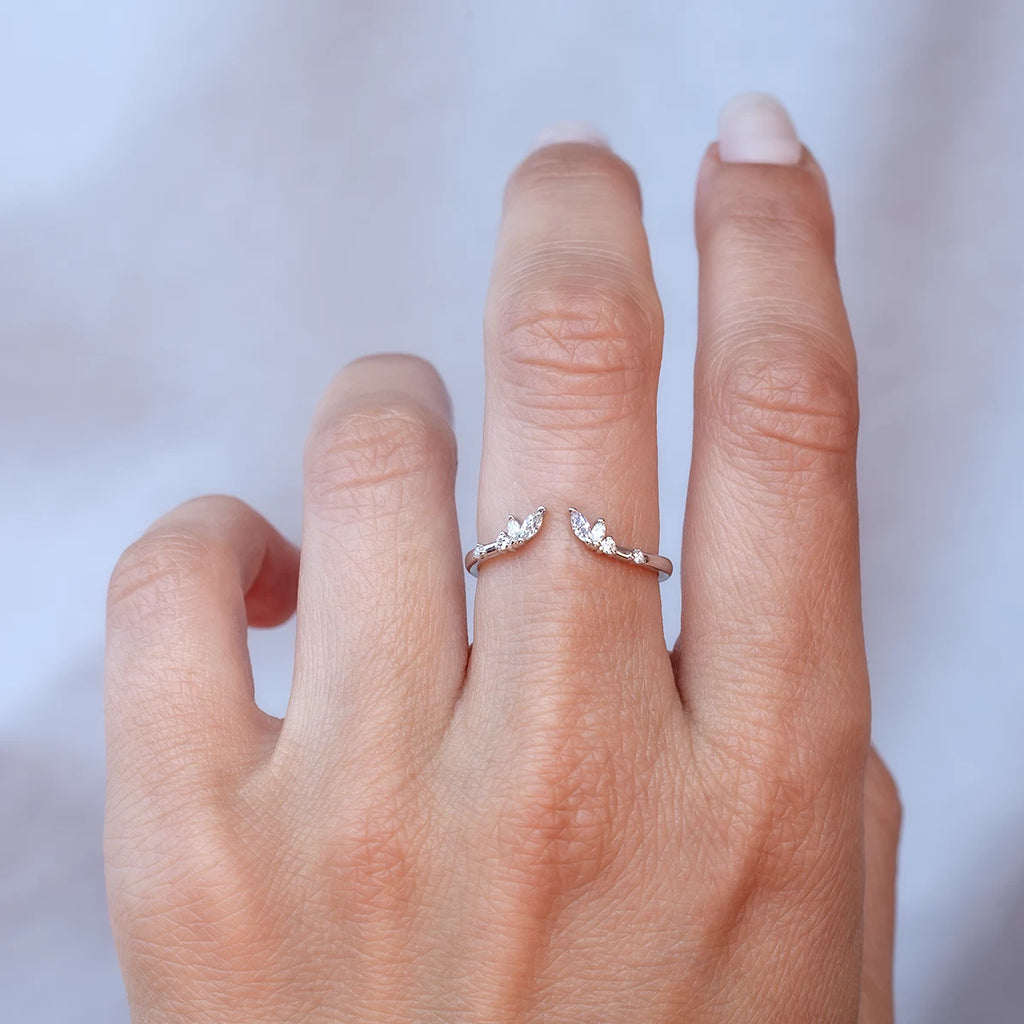 Open white gold diamond wedding band worn on a hand, featuring marquise and round diamonds arranged like delicate leaves, by Anastassia Sel, available at Ruby Mardi in Montreal.