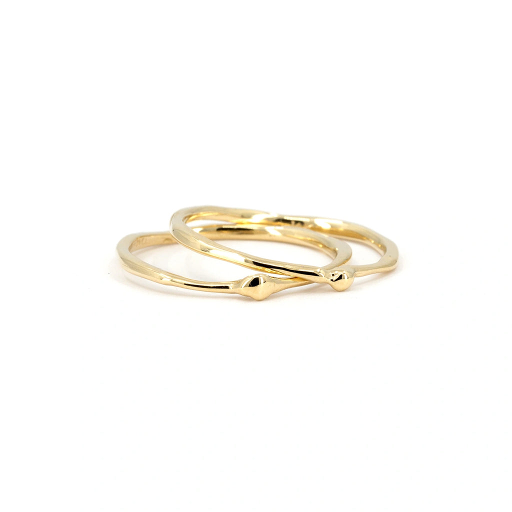 Pair of organic 14k yellow gold rings with sculptural fluid texture, handcrafted in Ottawa by Fluid Jewellery for Ruby Mardi. Photographed on white background.