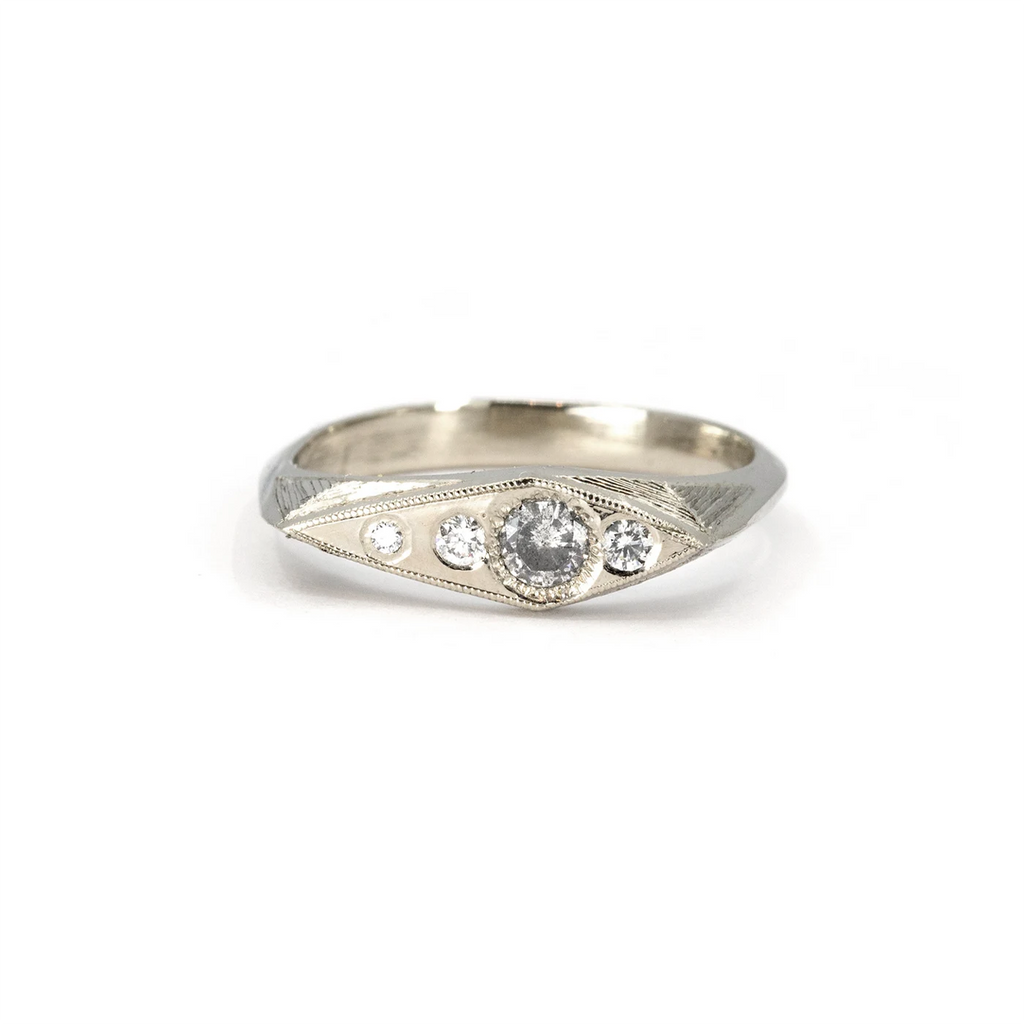 A white gold signet ring with diamonds and hand-engraved details, crafted by Rebel & Rogue and available at Ruby Mardi in Montreal.