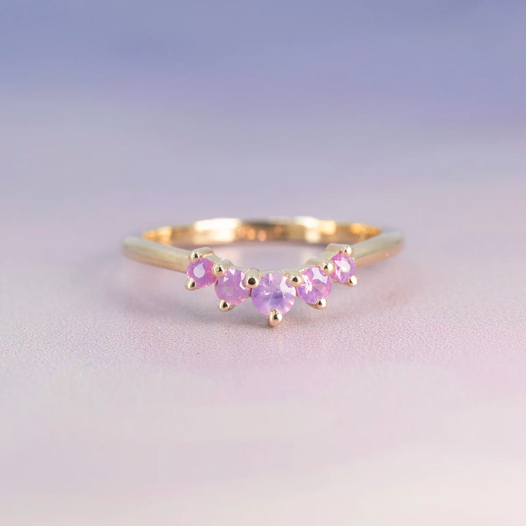 Bagatelle ring by Emily Gill featuring a curved band of silky pink sapphires in 14k yellow gold. Unique contour wedding band handmade in Canada, available at Ruby Mardi in Montreal.