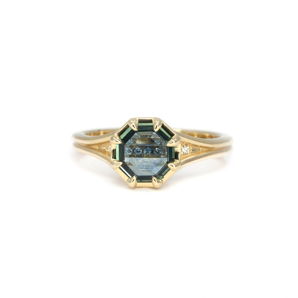 Portrait-cut Montana sapphire ring with diamond accents in split shank 14k yellow gold band, designed by Emily Gill and photographed on white background for Ruby Mardi, Montreal.