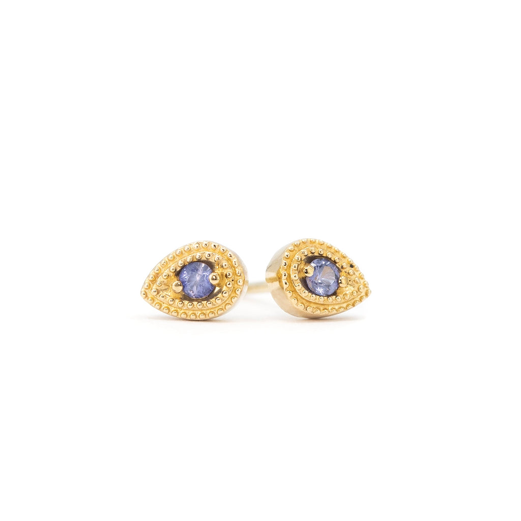 Stud earrings in 14k yellow gold, crafted by Canadian designer Emily Gill, featuring pear-shaped settings with fine milgrain details and set with round purple sapphires. Modern yet vintage-inspired jewelry, available at Ruby Mardi in Montreal.