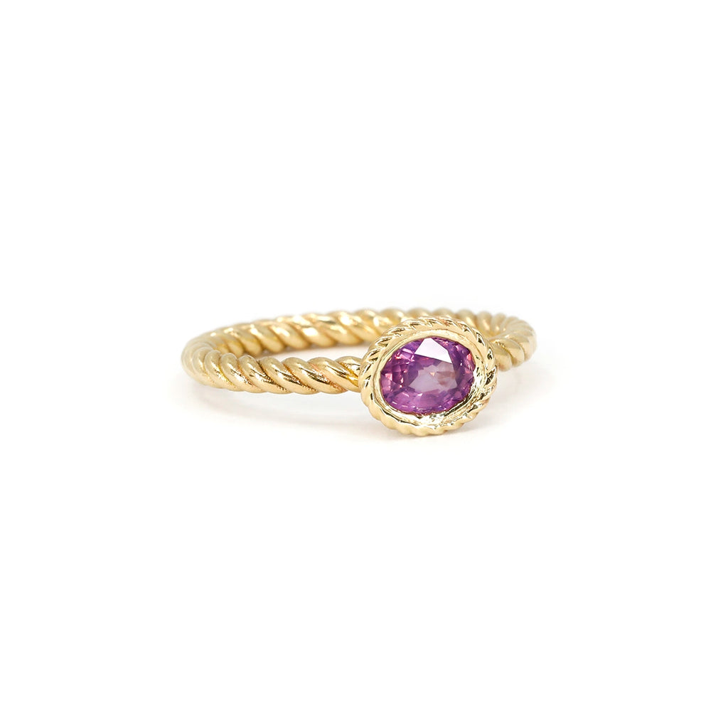 Gold ring with twisted band and bezel-set opalescent pink sapphire, oval cut, rope detailing. Raspberry Jam ring by In the Light of Day Jewelry, featured at Ruby Mardi in Montreal.