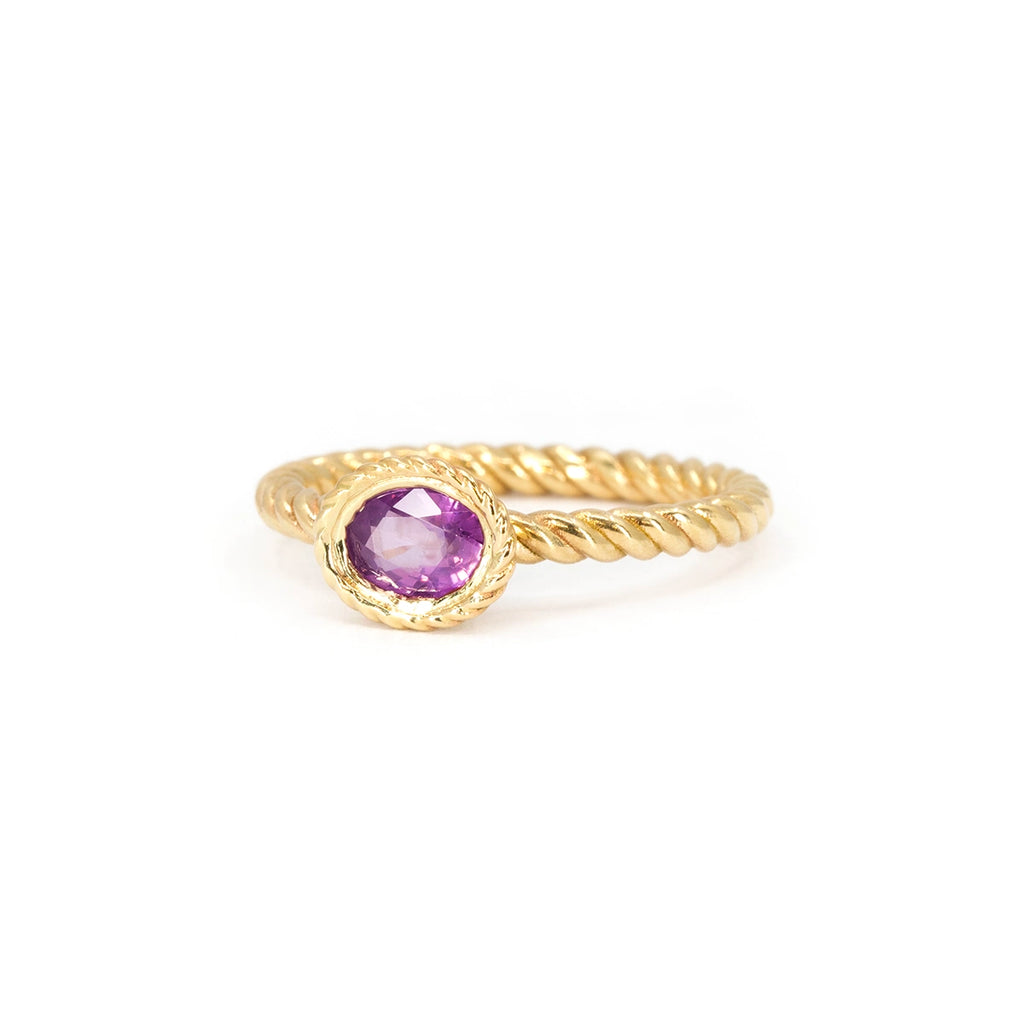 Twisted gold ring with bezel-set oval opalescent pink sapphire, featuring rope-textured details. Raspberry Jam ring by In the Light of Day Jewelry, available at Ruby Mardi in Montreal.