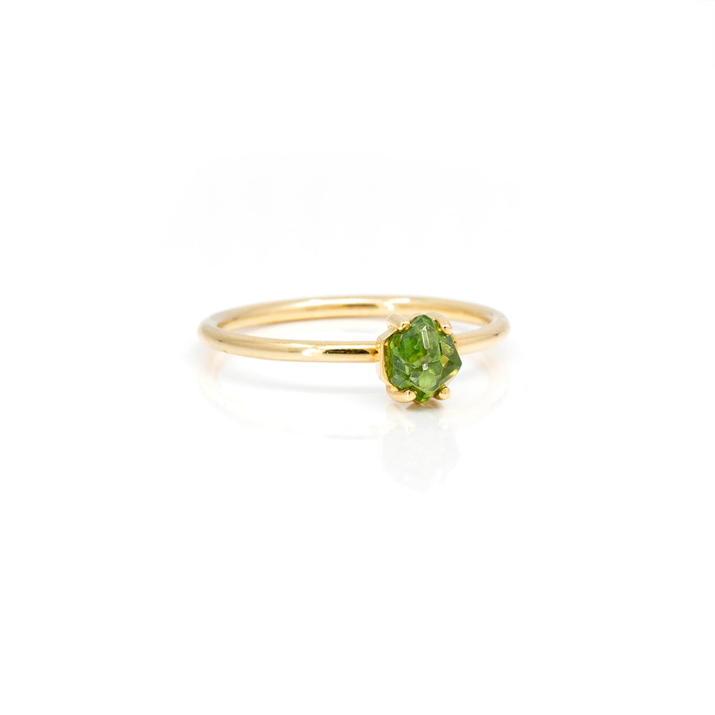 Front view of an engagement ring handmade in Montreal by the independent jeweller Francois Charest and featuring an ethical gemstone (a rough demantoid garnet) from Quebec mounted on a gold ring. This solitaire alternative engagment ring is available at fine jewelry store Ruby Mardi. It is seen here on a white background.