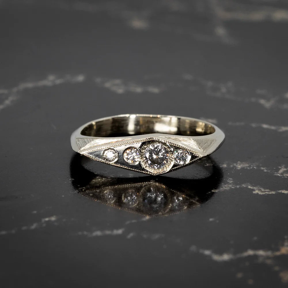 White gold ring by Rebel and Rogue, featuring natural diamonds and artisanal hand-engraved milgrain details. Available at Ruby Mardi, Montreal.