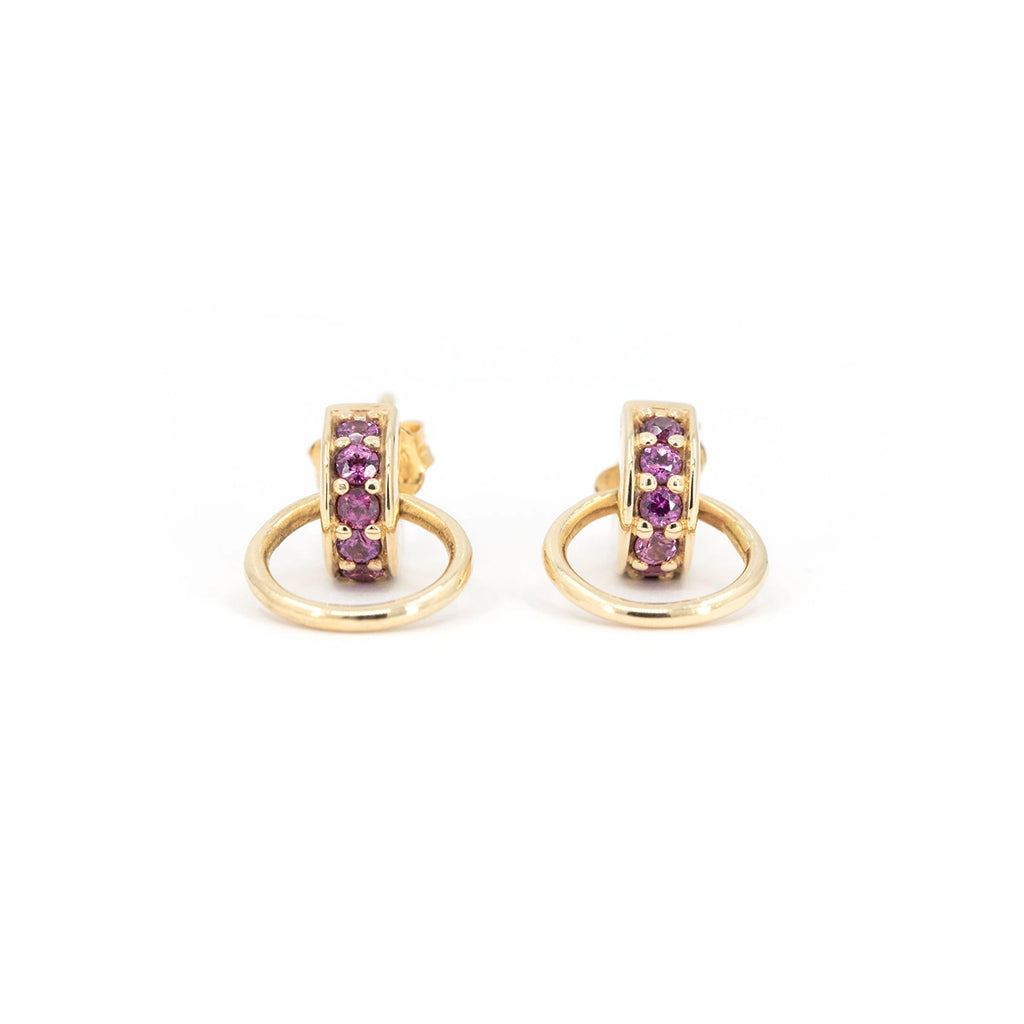 Rhodolite garnet door knocker stud earrings in yellow gold by Bena Jewelry, designer fine jewelry made in Montreal, Canada. Contemporary unisex design with pink-purple rhodolite garnets set in a vertical bar and a gold circular hoop detail. Elegant yet edgy earrings photographed on white background for Ruby Mardi.