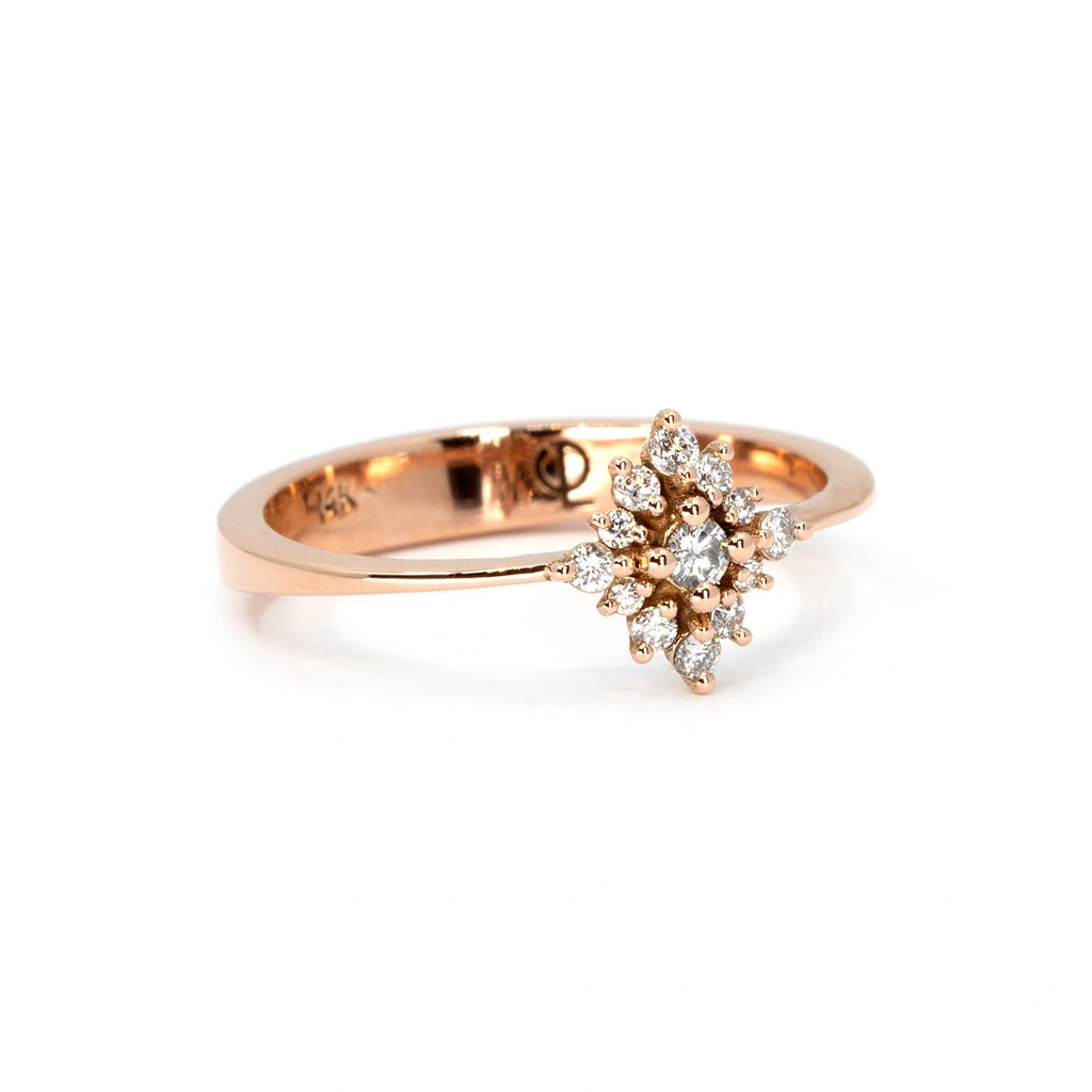 The Solstice ring, an ethereal 14k rose gold piece adorned with a dazzling starburst diamond cluster. Its radiant design captures celestial beauty with a delicate yet striking presence. Available at Ruby Mardi, a Montreal-based independent jewelry boutique specializing in custom creations.