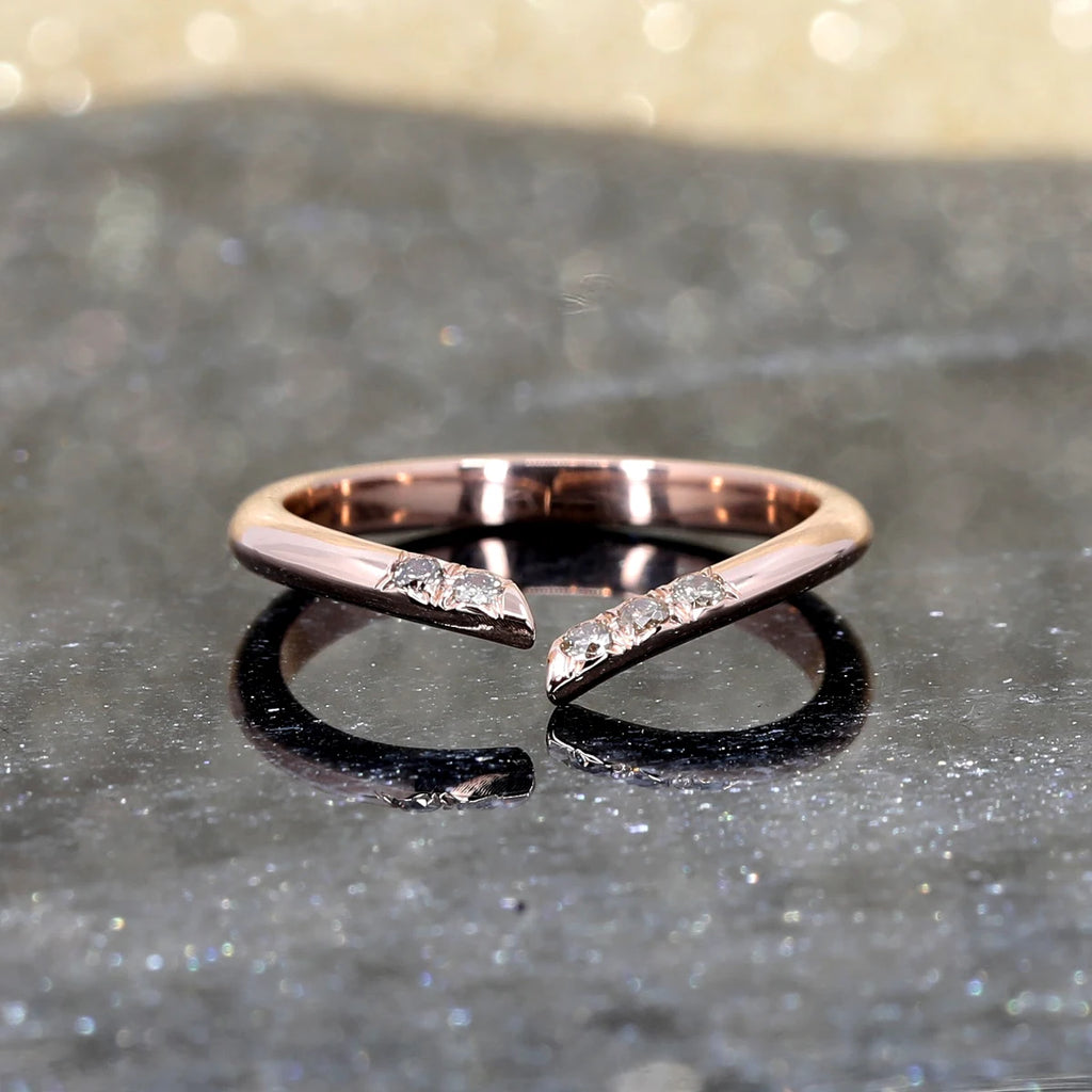 A designer ring show photographed on a black marble. The wedding band is made of rose gold and shows 5 natural champagne diamonds on the band. It is handmade in Montreal by independent jewellers Ruby Mardi.
