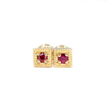 14k gold ruby stud earrings by Canadian designer Emily Gill. Square setting with milgrain texture and round rubies. Shown on white background. Available at Ruby Mardi, Montreal.