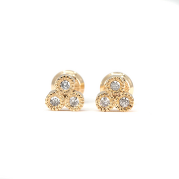 Close-up of gold stud earrings featuring three clustered salt and pepper diamonds with milgrain bezel settings. Designed by Emily Gill and available at Ruby Mardi, fine jewelry boutique in Montreal, Canada.