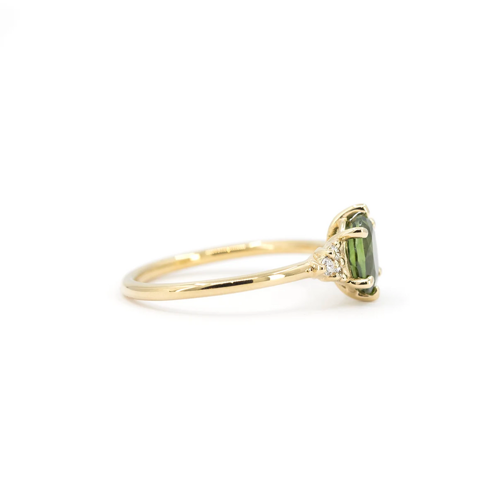Side view of oval green sapphire and diamond ring in yellow gold. Montreal-made by Maksym Jewelry, available at Ruby Mardi.