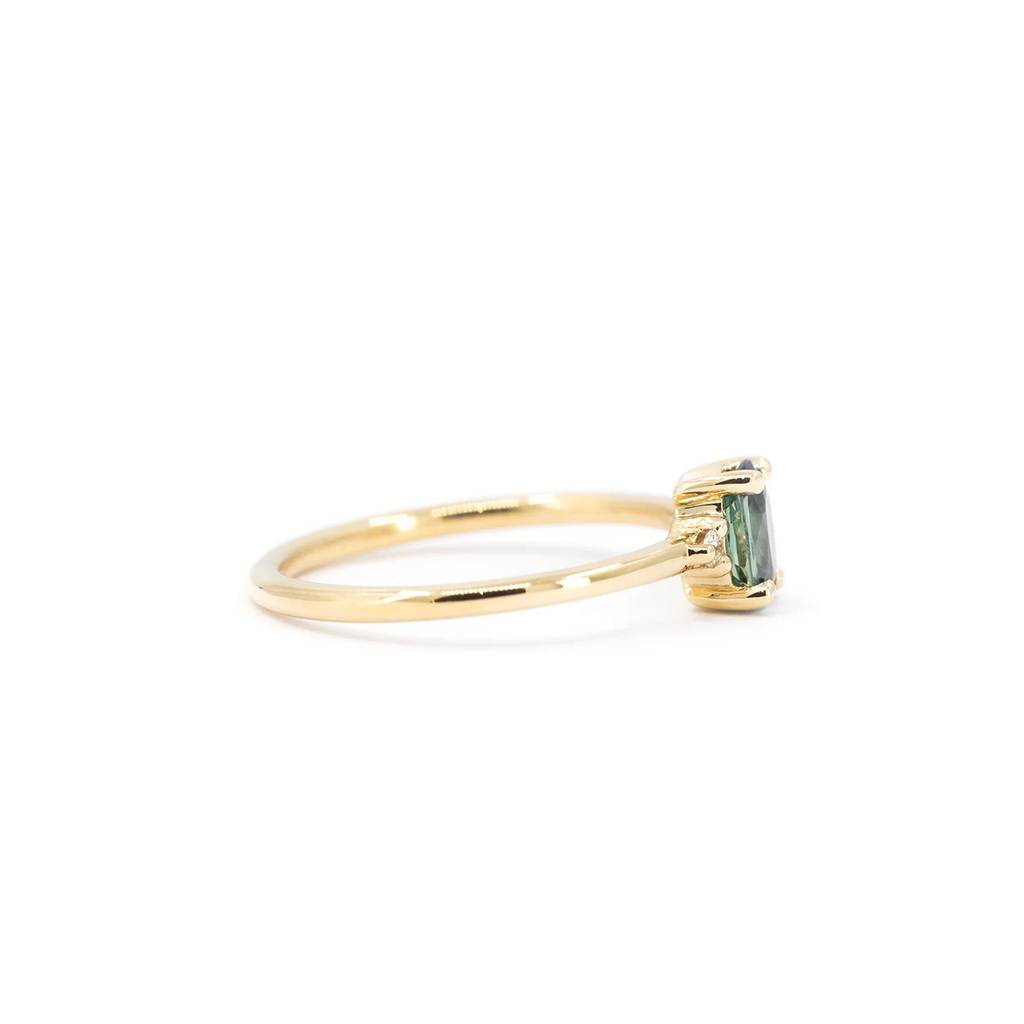 Side view of yellow gold sapphire engagement ring with teal center stone and prong setting. Made in Montreal by Maksym Jewelry for Ruby Mardi.