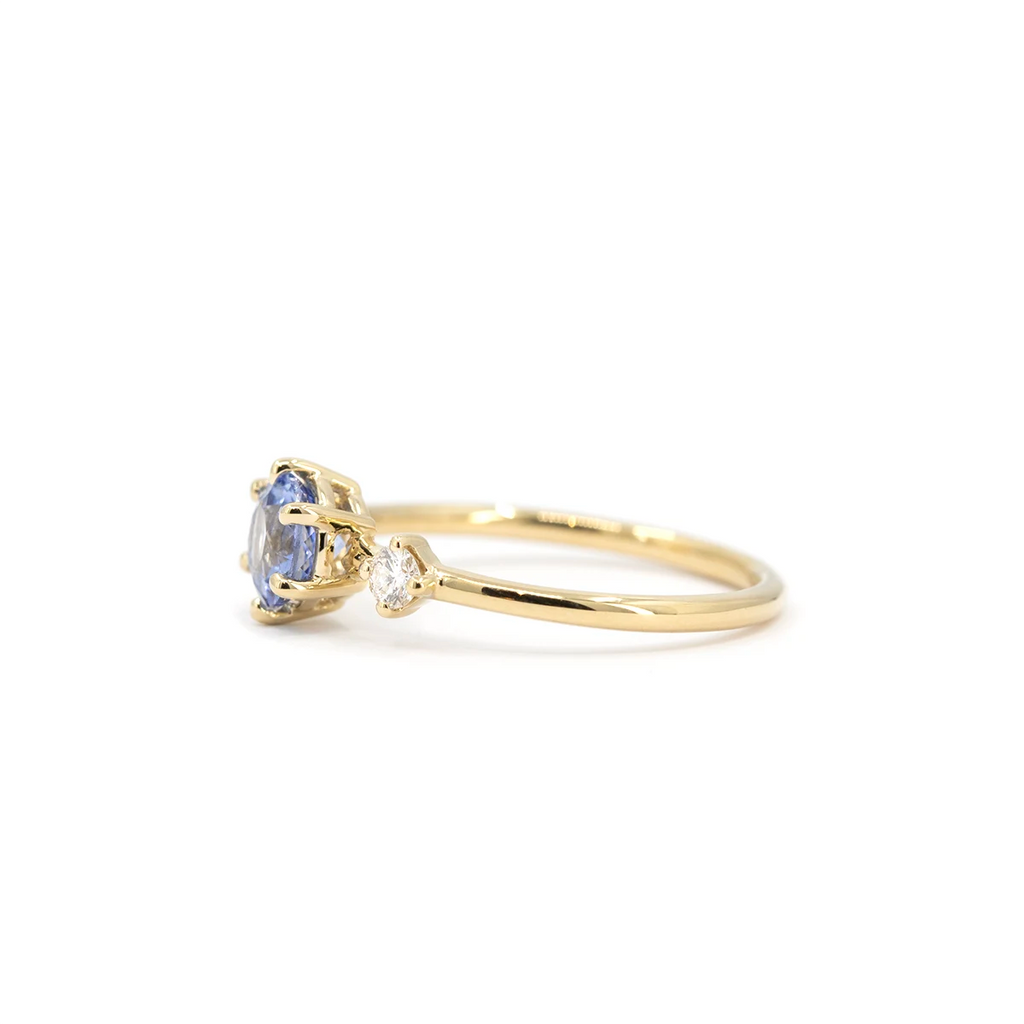 Side view of light blue sapphire and diamond engagement ring in yellow gold. Handmade by Maksym Jewelry in Montreal, available at Ruby Mardi.
