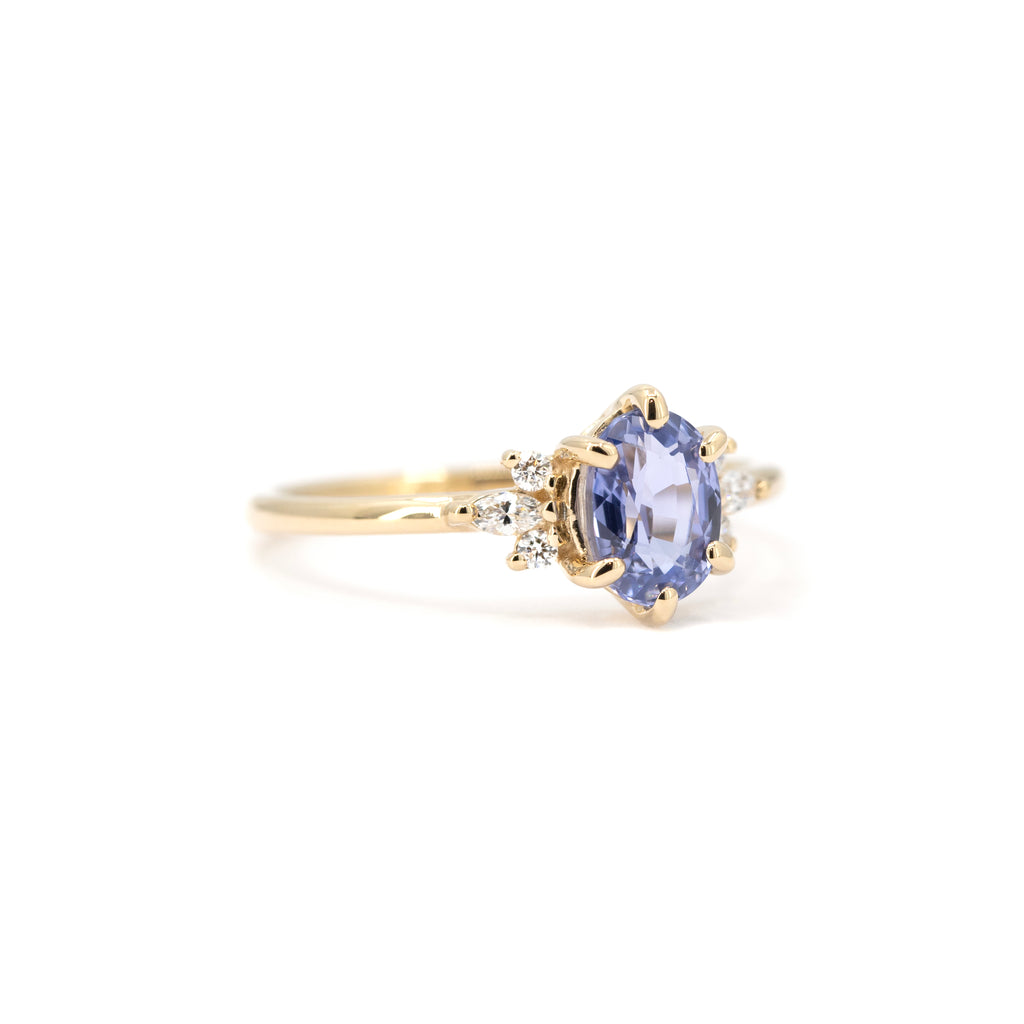 Sky blue sapphire and diamond engagement ring in yellow gold, angled view. Handmade by Maksym Jewelry, exclusive to Ruby Mardi, Montreal.
