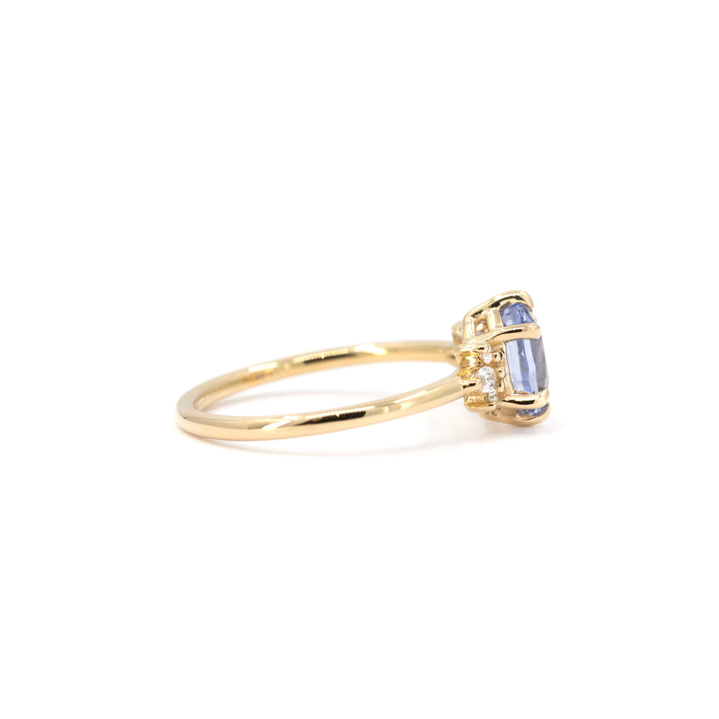 Side profile of a light blue sapphire ring with diamond accents, 14k yellow gold setting by Maksym Jewelry, designed in Montreal for Ruby Mardi.