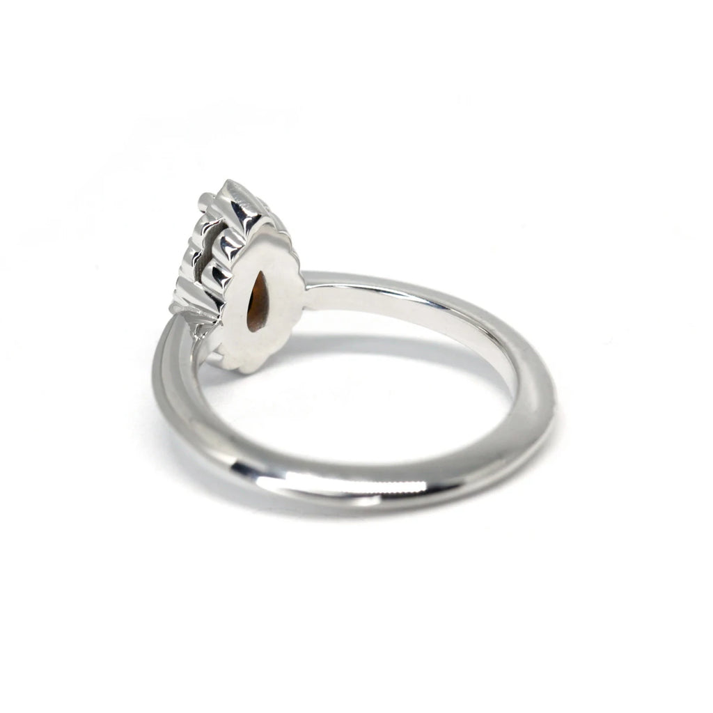Back view on a white background of a classic engagement ring in white gold with a halo of natural diamonds and a spessartite garnet, which is an orange gemstone, as the central gem.