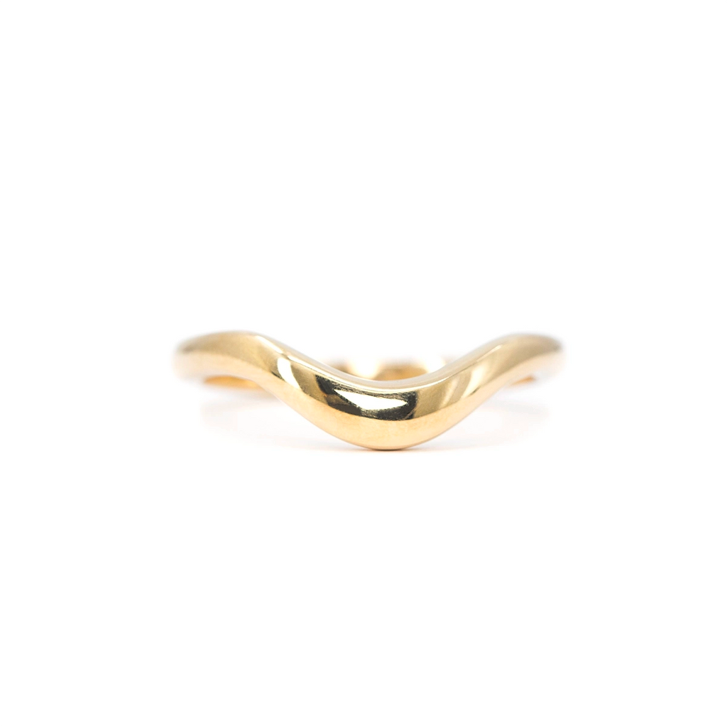 Minimalist curved gold wedding band handcrafted by Canadian designer Yuliya Chorna. Available at Ruby Mardi, a fine jewelry boutique in Montreal, Canada.