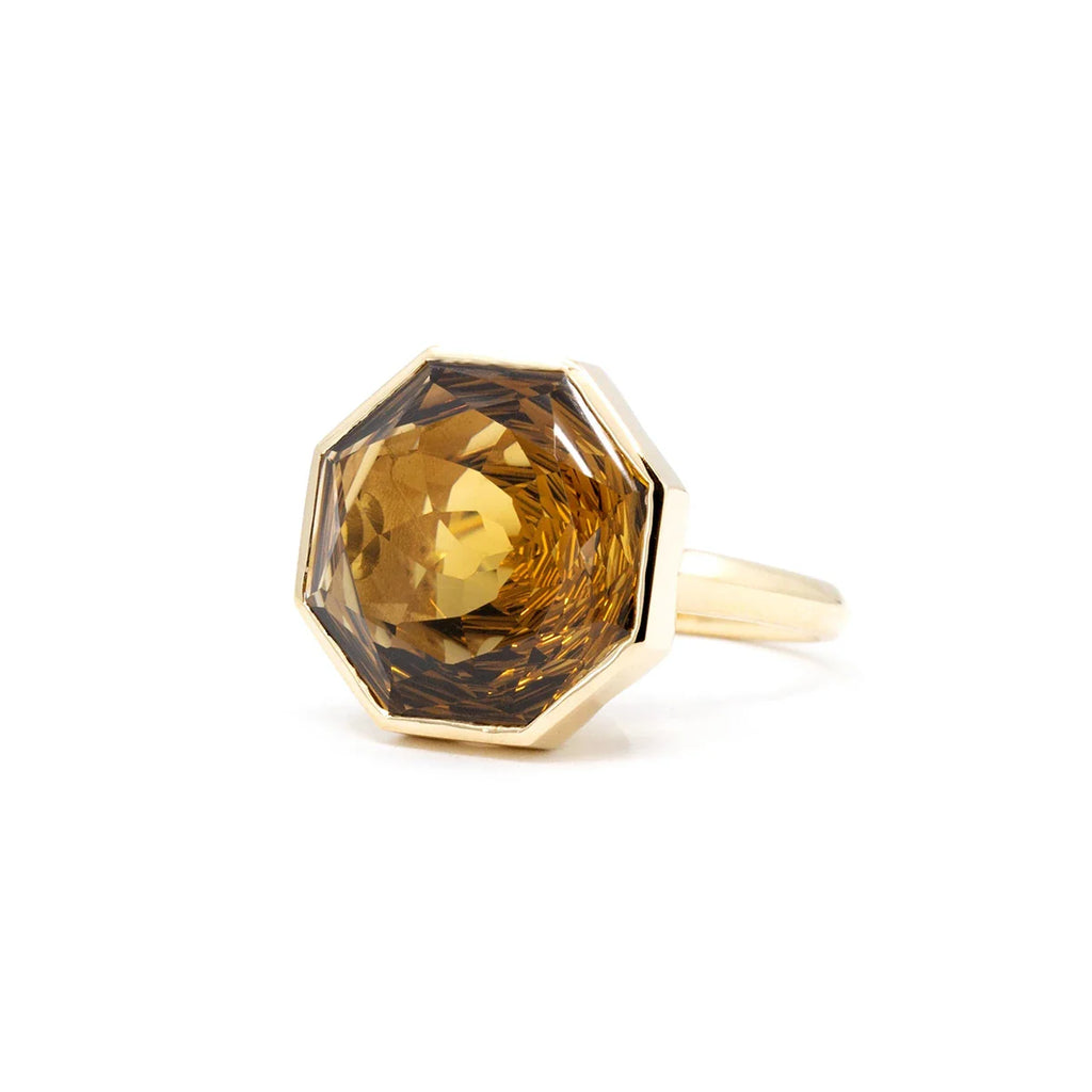 Big octagonal citrine (a nautral gemstone with hues of yellow and dark brown) is photographed on close up against a white background. It's a unique design from Bena Jewelry, an independent Canadian fine jewellery brand that makes statement jewelry and unisex rings.