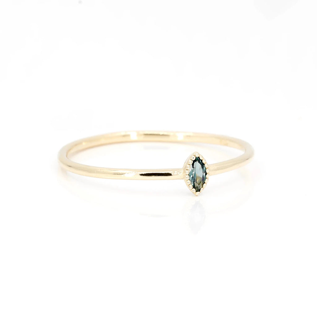 This pretty yellow gold ring in closed setting, with a marquise sapphire, made in Quebec by the independent jewelry designer Émigé in collaboration with the Ruby Mardi jewelry store in Montreal, specialist in handmade jewelry by artisan jewelers. This delicate, alternative bridal ring is simple and minimalist.