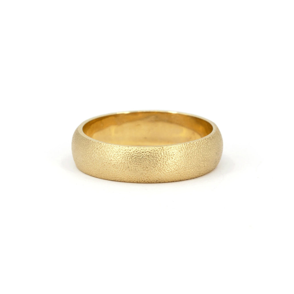 Textured gold wedding band with a soft satin finish, handcrafted for a timeless and organic look. Available at Ruby Mardi, Montreal’s fine jewelry gallery.