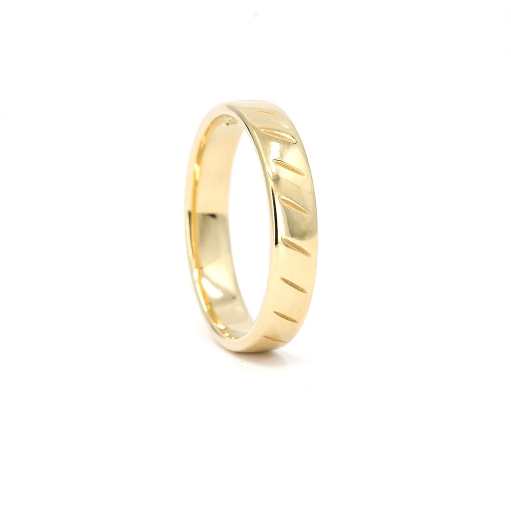 Yellow gold wedding band with carved diagonal lines on the surface. Fine men’s ring handcrafted in Montreal by Ruby Mardi.