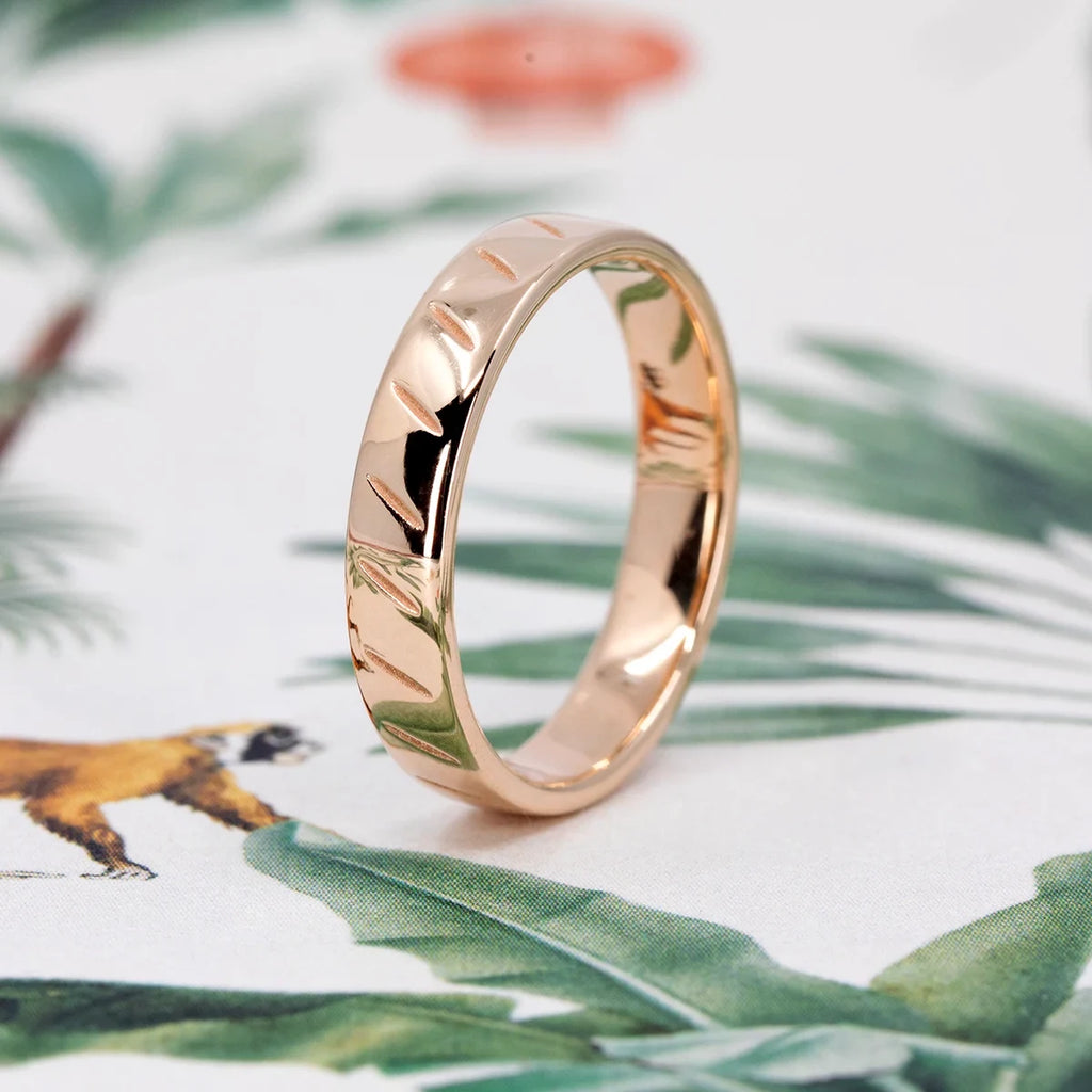 Polished rose gold wedding band featuring engraved diagonal lines, modern and minimal, handcrafted by Ruby Mardi in Montreal.