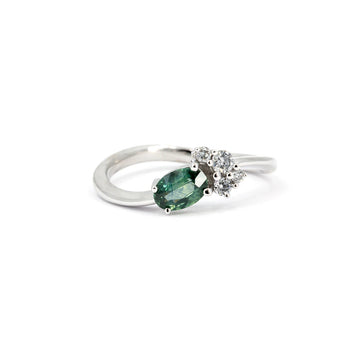 Twisted band engagement ring in white gold featuring an oval-cut green-blue Montana sapphire and two round diamonds, contemporary design by Justine Quintal for Ruby Mardi, made in Montreal, Canada.