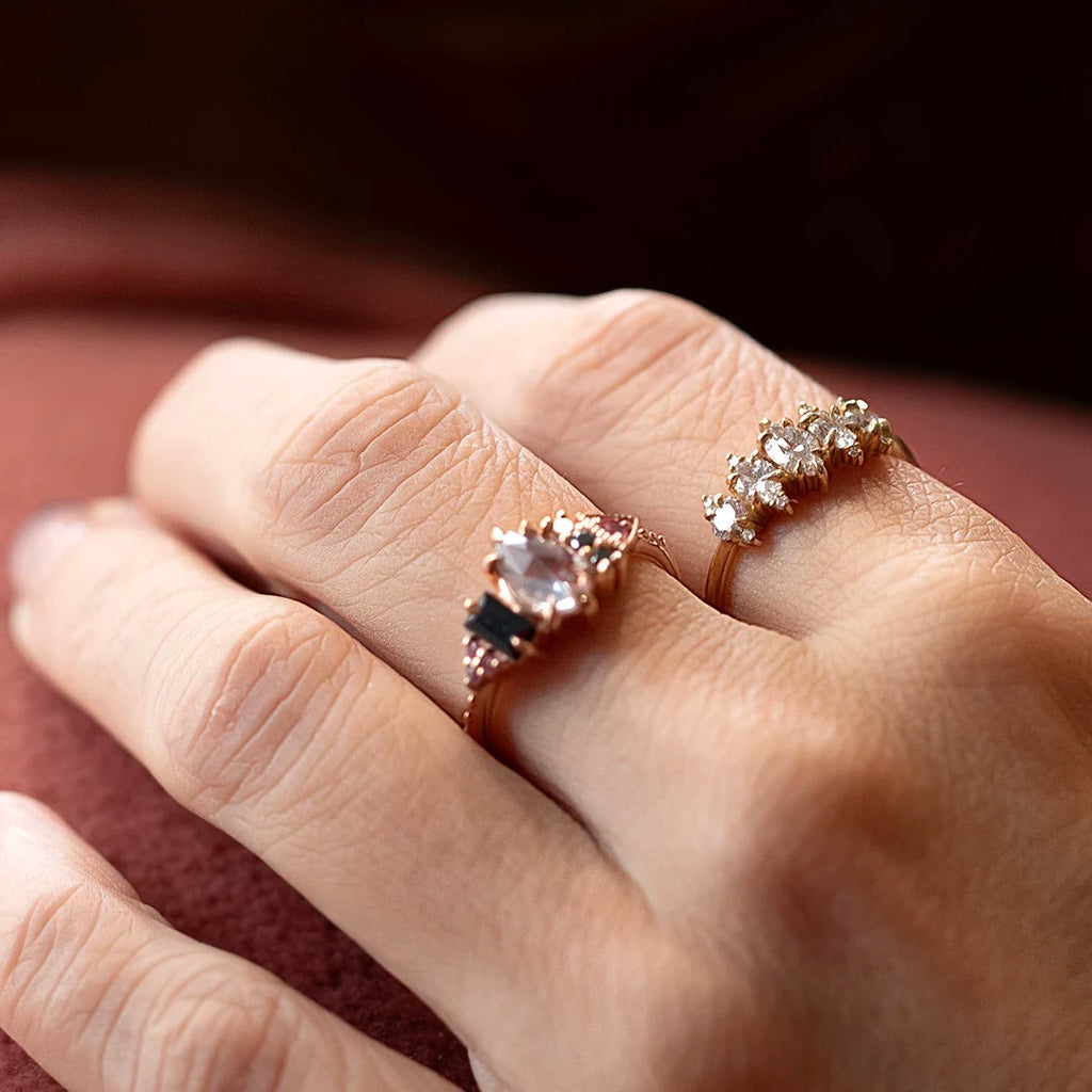 Hands wearing the Sereia diamond ring by Canadian jeweller Nadia Werchola, crafted in 10k yellow gold. The ring features shimmering lab-created diamonds and a soft, organic silhouette, photographed on a warm fabric background.
